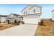 Charming two-story home with light gray siding, a two-car garage, and a long concrete driveway at 2036 Avalon Rdg, Conyers, GA 30013