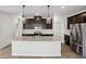 A kitchen with dark cabinets, stainless steel appliances, a center island and pendant lighting at 2036 Avalon Rdg, Conyers, GA 30013