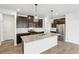 A kitchen with dark cabinets, stainless steel appliances, a center island and pendant lighting at 2036 Avalon Rdg, Conyers, GA 30013