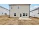 Home back exterior featuring neutral siding, walkout patio, and a manicured lawn at 2038 Avalon Rdg, Conyers, GA 30013