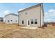 Backyard showcasing house siding, windows, and outdoor patio on a sunny day with grass growing at 2038 Avalon Rdg, Conyers, GA 30013