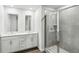 Modern bathroom featuring double vanity, sleek mirrors, and a glass-enclosed shower with gray tiling at 2038 Avalon Rdg, Conyers, GA 30013