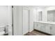 Clean, modern bathroom design featuring double vanity, mirrors, white walls and wood-look floor at 2038 Avalon Rdg, Conyers, GA 30013