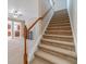 Beige carpeted staircase with wooden handrail at 3365 Sardis Bend Dr, Buford, GA 30519