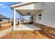 Covered patio with ceiling fan, stone accents, and backyard view at 111 Camilla Dr, Carrollton, GA 30116