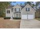Two-story brick home with a two-car garage and landscaped lawn at 6876 Wildboar Dr, Fairburn, GA 30213