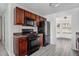 Kitchen with dark wood cabinets, black appliances, and gray vinyl flooring at 6876 Wildboar Dr, Fairburn, GA 30213