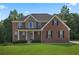 Brick two-story house with stone accents, a large front yard, and a covered porch at 3247 Brigadier Way, Stockbridge, GA 30281