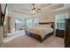 Large main bedroom with tray ceiling, carpet, and ensuite bathroom access at 3247 Brigadier Way, Stockbridge, GA 30281