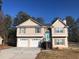 Two-story house featuring a two car garage and a light teal front door at 114 Muirwood Dr, Temple, GA 30179