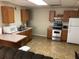 Galley kitchen with wood cabinets, appliances, and tile floor at 114 Muirwood Dr, Temple, GA 30179