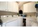 Bright laundry room features white cabinetry, a sink, and washer and dryer at 4685 Prater Se Way, Smyrna, GA 30080