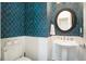 Stylish powder room boasts modern wallpaper, pedestal sink, and elegant fixtures at 4685 Prater Se Way, Smyrna, GA 30080