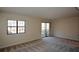 Living room featuring carpeted floors, large windows, and sliding glass door to balcony at 475 Mount Vernon Ne Hwy # C-220, Sandy Springs, GA 30338