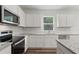 Kitchen area featuring stainless steel appliances, granite countertops, white cabinets and a subway tile backsplash at 386 Rock View Ln, Covington, GA 30016