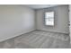 Well-lit bedroom with neutral carpeting and a window at 138 Longhorn Way, Auburn, GA 30011