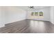 Spacious living room featuring hardwood floors, three windows, and a ceiling fan at 3250 Durston Ct, Dacula, GA 30019