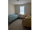 Bedroom with a comfortable bed and an inviting yellow sofa, creating a relaxing and versatile space at 6603 Biscayne Blvd, Rex, GA 30273