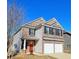 Two-story house with red front door, two-car garage, and brick exterior at 1103 Watercourse Way, Hampton, GA 30228