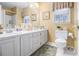 Bathroom with double sinks, large mirror, neutral decor and tile flooring at 3472 Honeycomb Se Dr, Conyers, GA 30094