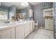 Bright primary bathroom with white vanity, double sinks, and tiled floor at 3472 Honeycomb Se Dr, Conyers, GA 30094