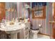 Cozy powder room featuring patterned wallpaper, bright window, and pedestal sink at 3472 Honeycomb Se Dr, Conyers, GA 30094