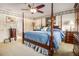 Bright bedroom featuring four-poster bed, ceiling fan, carpeted floors, and natural light at 3472 Honeycomb Se Dr, Conyers, GA 30094