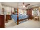 Bright bedroom featuring four-poster bed, ceiling fan, carpeted floors, and natural light at 3472 Honeycomb Se Dr, Conyers, GA 30094