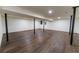 This basement area features wood-look floors, support beams, and recessed lighting at 3800 William Paul Dr, Austell, GA 30106