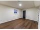 Finished basement area with wood-look floors, a small window, and a black door to the outside at 3800 William Paul Dr, Austell, GA 30106