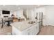 Open kitchen with large island, stainless steel appliances, and views into living area at 7767 Richmond Trl, Fairburn, GA 30213