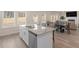 Open kitchen with island, stainless steel appliances, and views to the dining and living areas at 7767 Richmond Trl, Fairburn, GA 30213