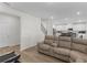 Living room with a sectional sofa and view into the kitchen and staircase at 7767 Richmond Trl, Fairburn, GA 30213