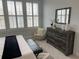 Bright bedroom showcasing shuttered windows, a comfortable chair, and a dresser with a decorative mirror at 58 Canton St # 303, Alpharetta, GA 30009