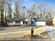 Ranch style home with stone chimney, attached garage, and mature trees at 4522 Karron Ln, Powder Springs, GA 30127