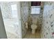 Small bathroom with toilet and bathtub, floral wallpaper at 95 Brandon Dr, Covington, GA 30016
