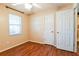 Bedroom with wood-look floors, window, and double doors to closet at 95 Brandon Dr, Covington, GA 30016