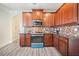 Kitchen with wood cabinets, granite counters, stainless steel microwave and stove, and light gray wood-style floors at 417 Culloden Moor Dr, Mcdonough, GA 30253