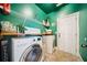 Well-lit laundry room with modern washer and dryer, shelving, and stylish decor at 417 Culloden Moor Dr, Mcdonough, GA 30253