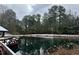 Snow covered wooden dock and pond with trees in background at 4361 Hardwood Sw Cir, Lilburn, GA 30047