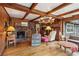 Rustic living room with wood beams, a brick fireplace, and built-in shelving at 3781 Narmore Ne Dr, Atlanta, GA 30319