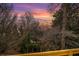 A tranquil view of the backyard through bare trees under a colorful sunset sky at 490 Rock Springs Ne Rd, Atlanta, GA 30324