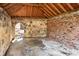 Interior of stone garage showcasing brick walls, concrete floor, and arched entrance to the surrounding yard at 490 Rock Springs Ne Rd, Atlanta, GA 30324