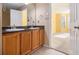 Double vanity bathroom with dark countertops and wood cabinets at 566 Maggie Ln, Jonesboro, GA 30238