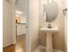 Small powder room with pedestal sink and oval mirror at 566 Maggie Ln, Jonesboro, GA 30238