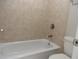Clean bathroom with tub and shower combination, featuring neutral tile and updated fixtures at 9400 Roberts Dr # 1C, Atlanta, GA 30350