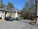 Exterior view of condo building with ample parking and tree-lined surroundings at 9400 Roberts Dr # 1C, Atlanta, GA 30350