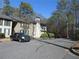 Exterior view of condo building with ample parking and tree-lined surroundings at 9400 Roberts Dr # 1C, Atlanta, GA 30350
