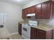 Small kitchen with white appliances and wood cabinets at 9400 Roberts Dr # 1C, Atlanta, GA 30350