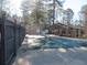 Community pool with safety cover, surrounded by a wooden fence and landscaping at 9400 Roberts Dr # 1C, Atlanta, GA 30350